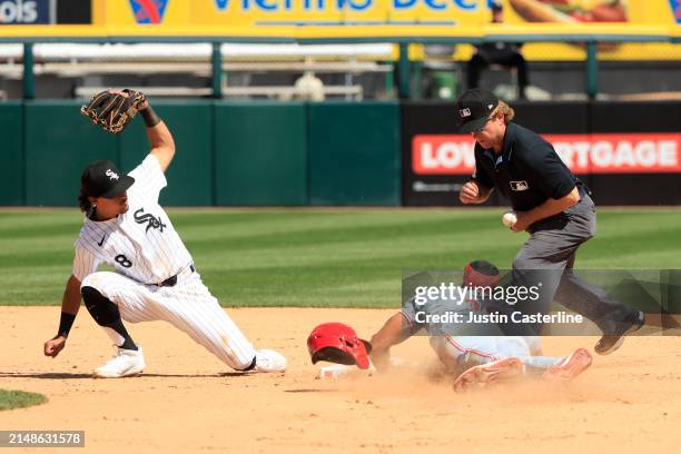 Second base umpire Mike Muchlinski blocks the ball as Will Benson of the Cincinnati Reds slides into second base in the game against the Chicago...