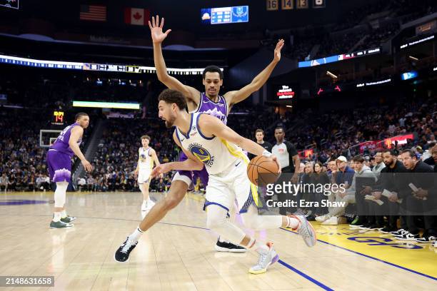 Klay Thompson of the Golden State Warriors is guarded by Darius Bazley of the Utah Jazz in the first half at Chase Center on April 14, 2024 in San...