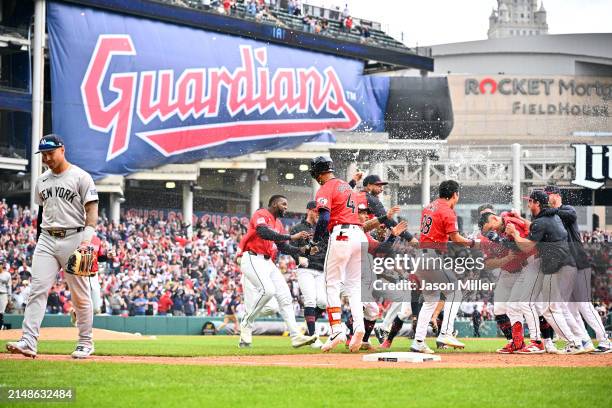 Gleyber Torres of the New York Yankees walks off the field while the Cleveland Guardians celebrate after Andrés Giménez hit a walk-off sacrifice fly...