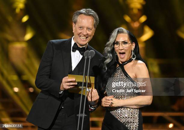 Richard E. Grant and Michelle Visage presenting on stage during The Olivier Awards 2024 at The Royal Albert Hall on April 14, 2024 in London, England.