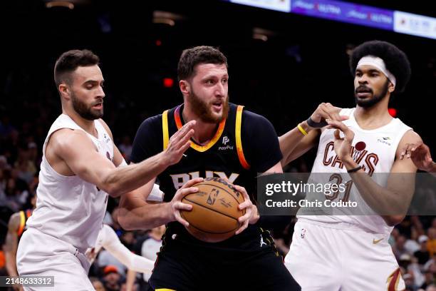 Jusuf Nurkic of the Phoenix Suns controls a rebound against Max Strus and Jarrett Allen of the Cleveland Cavaliers during the game at Footprint...