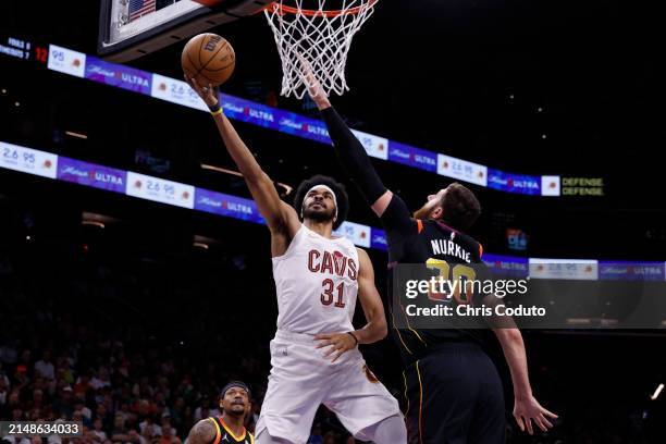 Jarrett Allen of the Cleveland Cavaliers attempts a shot over Jusuf Nurkic of the Phoenix Suns during the game at Footprint Center on April 03, 2024...