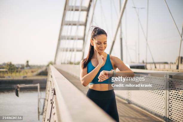 a young fitness woman checks her pulse on her neck. - fitness or vitality or sport and women stockfoto's en -beelden