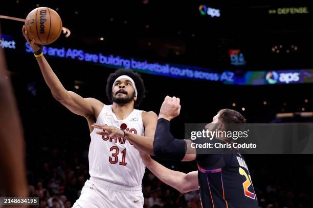 Jarrett Allen of the Cleveland Cavaliers attempts a shot over Jusuf Nurkic of the Phoenix Suns during the game at Footprint Center on April 03, 2024...