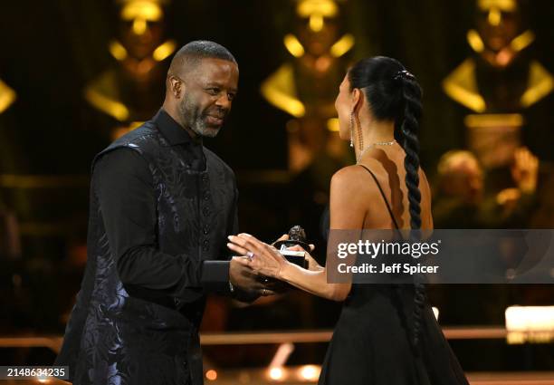 Adrian Lester presents Nicole Scherzinger with the Best Actress in a Musical award on stage during The Olivier Awards 2024 at The Royal Albert Hall...