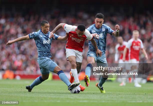 Gabriel Jesus of Arsenal is tackled by Youri Tielemans and Morgan Rogers of Aston Villa during the Premier League match between Arsenal FC and Aston...