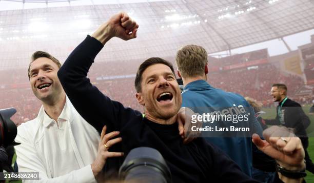 Xabi Alonso, Head Coach of Bayer Leverkusen, celebrates with manager Simon Rolfes after winning the Bundesliga match between Bayer 04 Leverkusen and...
