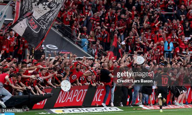 Florian Wirtz of Bayer Leverkusen celebrates after scoring his teams fourth goal while fans invaded the pitch during the Bundesliga match between...