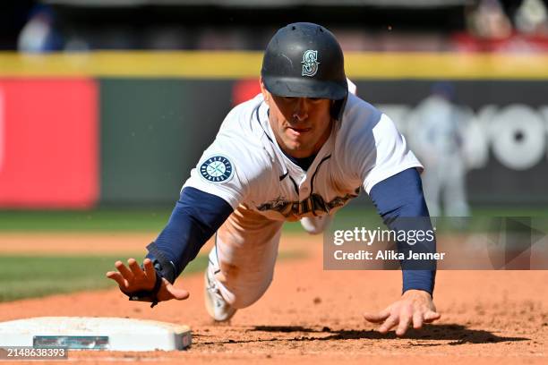 Dylan Moore of the Seattle Mariners dives back to first base during the seventh inning against the Chicago Cubs at T-Mobile Park on April 14, 2024 in...