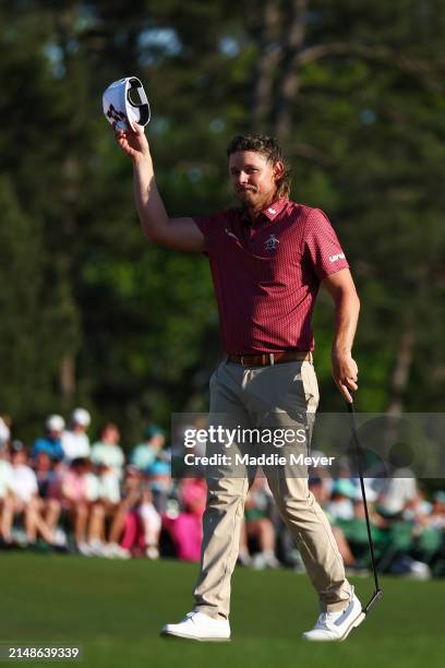 Cameron Smith of Australia waves his hat to the crowd on the 18th green during the final round of the 2024 Masters Tournament at Augusta National...