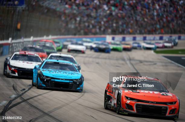 Chase Elliott, driver of the Hooters Chevrolet, leads the field during the NASCAR Cup Series AutoTrader EchoPark Automotive 400 at Texas Motor...