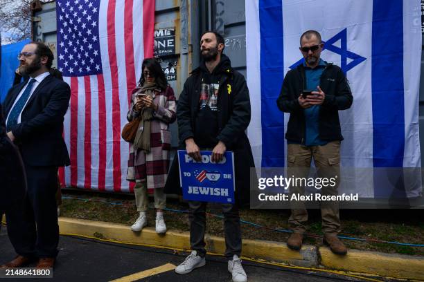 Daniel Lifshitz reacts to a speech while holding a "proud to be Jewish" sign before speaking at the six month "Bring Them Home Now" rally on April...