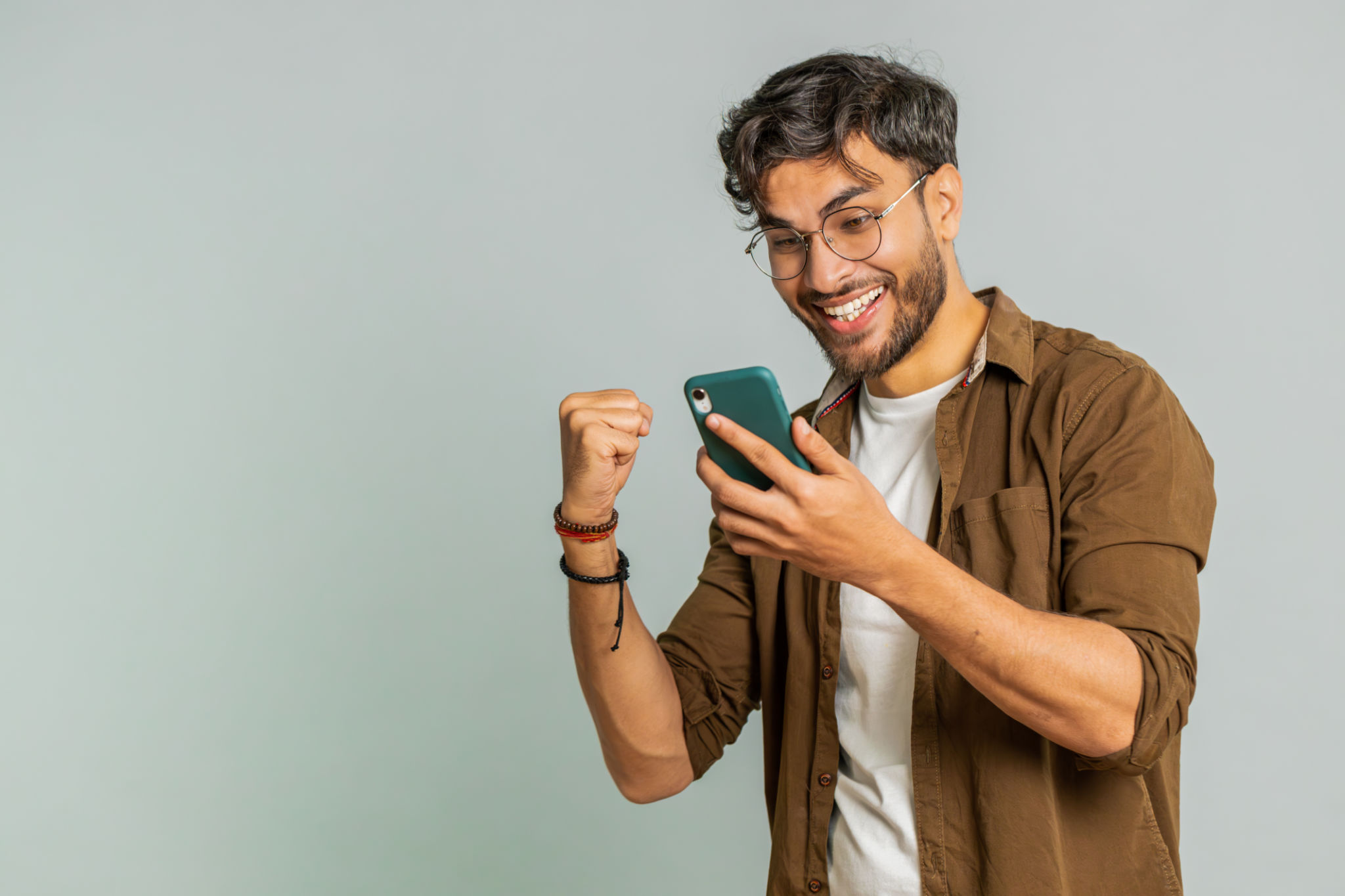 Happy excited winner man use smartphone celebrating success, winning play game, good lottery news Happy excited winner man use smartphone celebrating success, winning play game, good lottery news