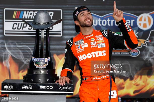 Chase Elliott, driver of the Hooters Chevrolet, celebrates in victory lane after winning the NASCAR Cup Series AutoTrader EchoPark Automotive 400 at...