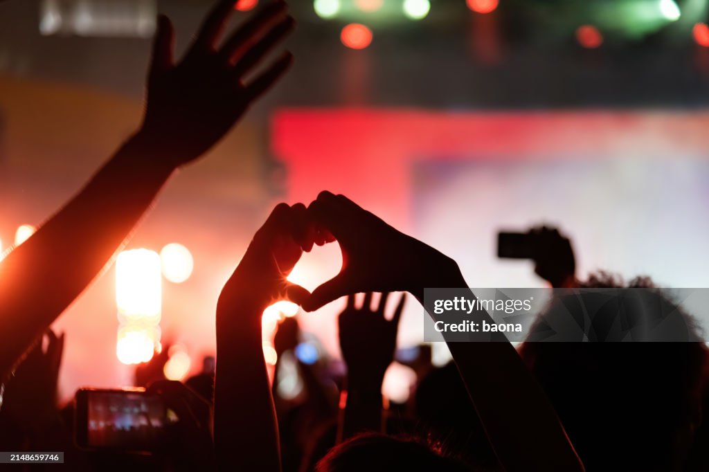 Hands making heart shape at music festival