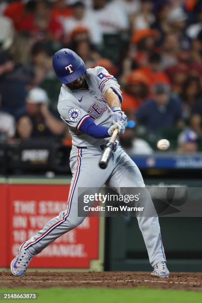 Marcus Semien of the Texas Rangers hits a RBI double in the fifth inning against the Houston Astros at Minute Maid Park on April 14, 2024 in Houston,...