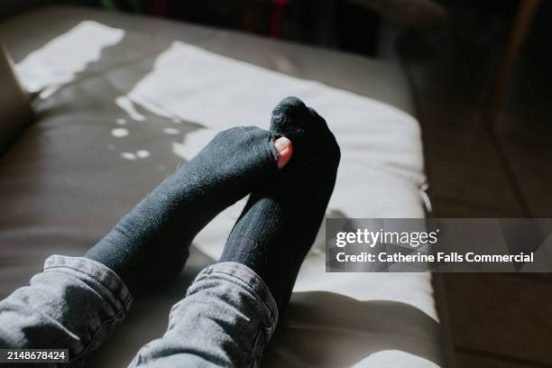 close-up of feet with a hole in black sock - sock stock pictures, royalty-free photos & images