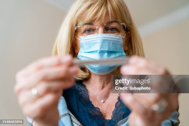 sick woman at home with flu virus having fever. - 2020 review stock pictures, royalty-free photos & images