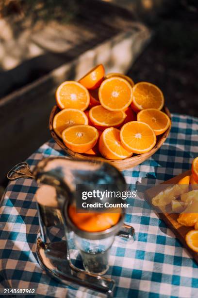 cut oranges on table in sun - vitamina c foto e immagini stock