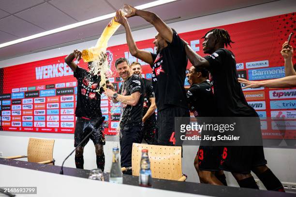 Headcoach Xabi Alonso of Leverkusen getting a beer shower by his players during the press conference after the Bundesliga match between Bayer 04...