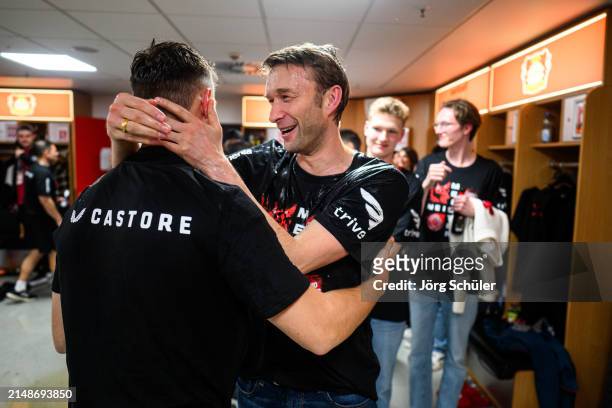 Sporting Director Simon Rolfes Alonso of Leverkusen getting a beer shower by Josip Stanisic during the celebrations in the locker room after the...