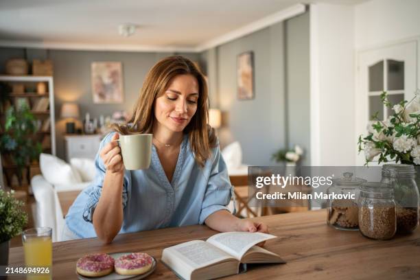 i love this quiet moment in the day with a good book and enjoying a weekend morning - milan markovic stock pictures, royalty-free photos & images