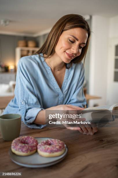 i love this quiet moment in the day with a good book and enjoying a weekend morning - milan markovic stock pictures, royalty-free photos & images