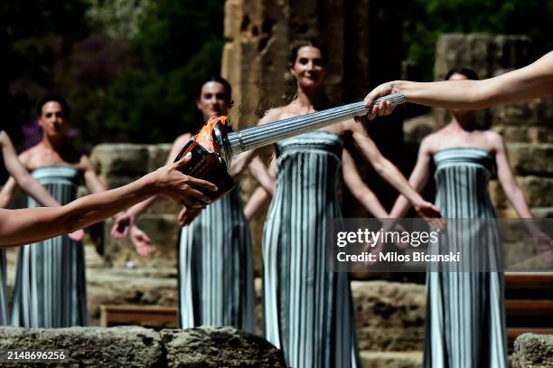 Greek actress Mary Mina, playing the role of the High Priestess, passes the flame to cauldron during the flame lighting ceremony for the Paris 2024...