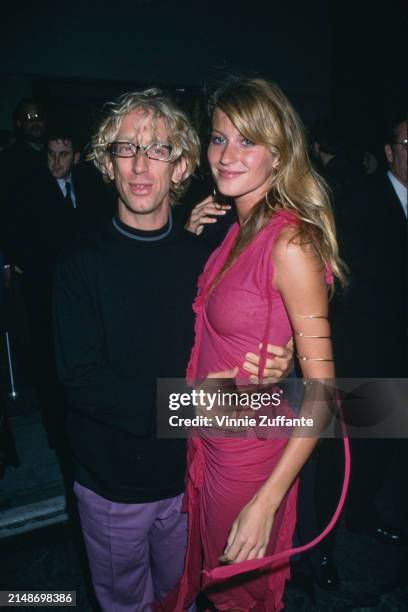 American comedian Andy Dick, wearing a black crew neck sweater with grey trim around the collar, and Brazilian fashion model Gisele Bundchen, who...