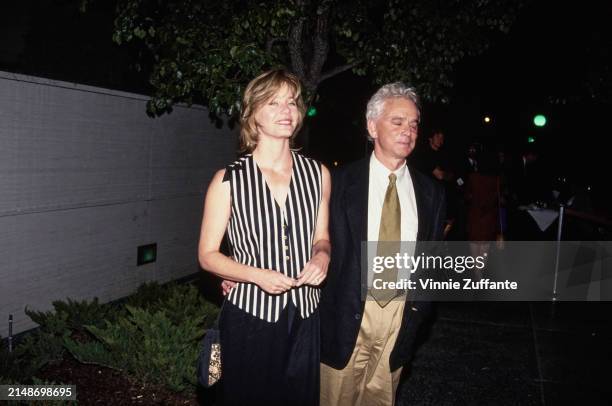 American actress Susan Dey, wearing a black-and-white striped button-front vest, and her husband, American film producer Bernard Sofronski, who wears...