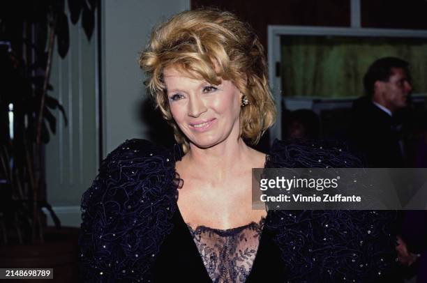 American actress Angie Dickinson, wearing a black evening gown with puff sleeves and black lace trim, attends the Bob Hope 35th Anniversary Special...