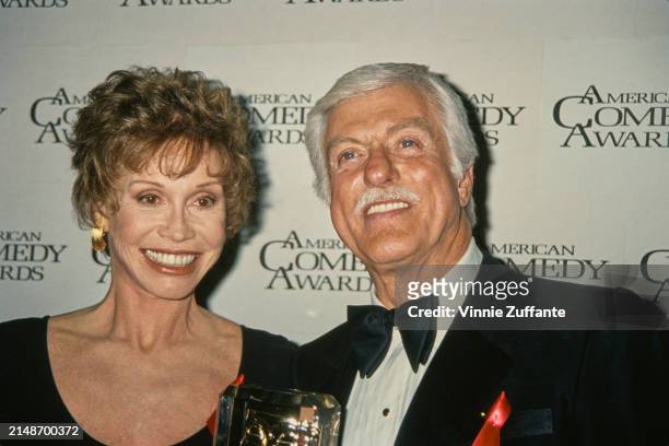 American actress Mary Tyler Moore, wearing a black scoop neck outfit, and American actor and comedian Dick Van Dyke, who wears a tuxedo and bow tie,...