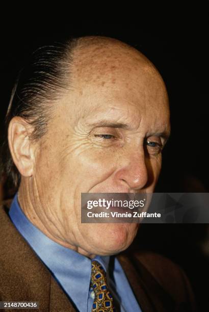 American actor Robert Duvall, wearing a brown blazer over a light blue shirt with a yellow-and-blue tie, attends the Beverly Hills premiere of...