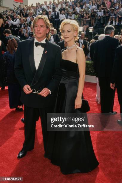 American actor John Dye, wearing a tuxedo and bow tie, and American actress Cheryl Pollak, who wears a black evening gown with spaghetti straps,...