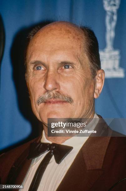 American actor Robert Duvall, wearing a brown blazer over a white shirt with a bow tie, in the 64th Academy Awards press room, at the Dorothy...