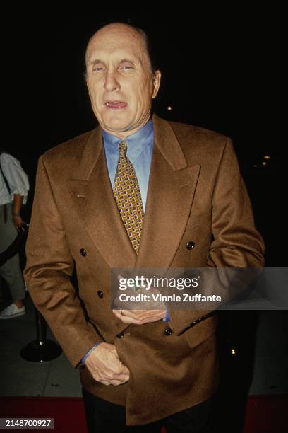 American actor Robert Duvall, wearing a brown blazer over a light blue shirt with a yellow-and-blue tie, attends the Beverly Hills premiere of...