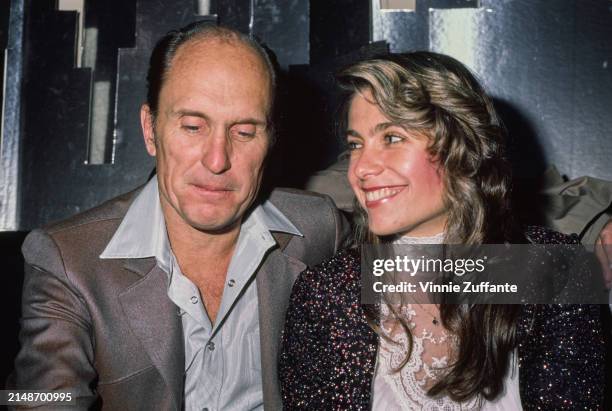 American actor Robert Duvall, wearing a grey jacket over a blue wide-collar shirt, and his wife, American actress Gail Youngs, who wears a sequin...