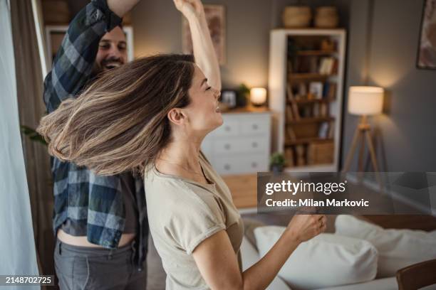 a wonderful scene of love and happiness between a couple in love enjoying their apartment - milan markovic stock pictures, royalty-free photos & images