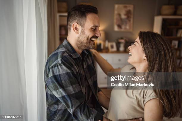 a wonderful scene of love and happiness between a couple in love enjoying their apartment - milan markovic stock pictures, royalty-free photos & images