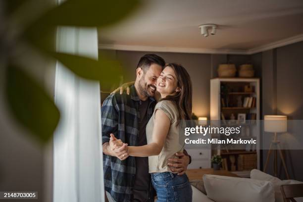 a wonderful scene of love and happiness between a couple in love enjoying their apartment - milan markovic stock pictures, royalty-free photos & images