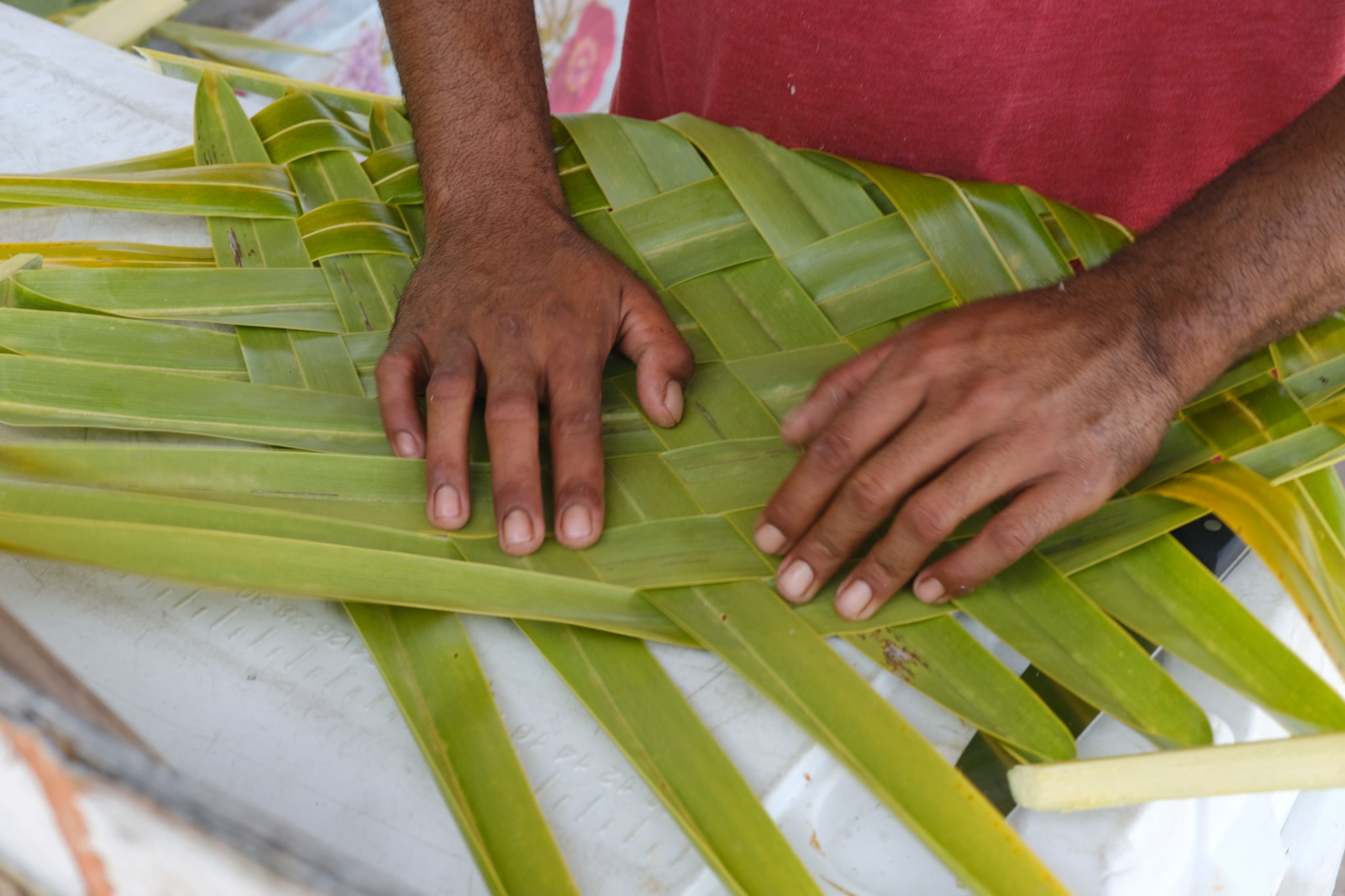 A Balinese man braids palm leaves for building in Bukit Peninsula, Bali.. A Balinese man braids palm leaves for building in Bukit Peninsula, Bali..
