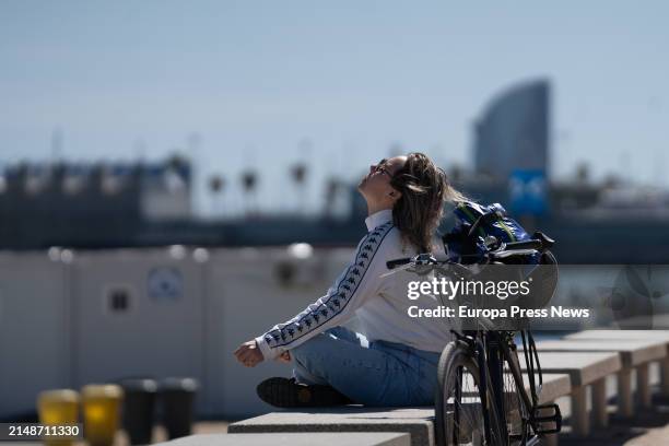 Woman sunbathes on the promenade of Bogatell beach, on 15 April, 2024 in Barcelona, Catalonia, Spain. Catalonia has registered this April 13 and 14 a...