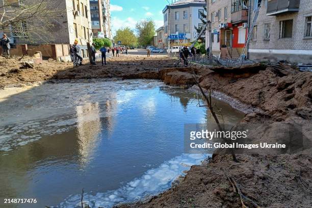Missile crater near a five-story residential building remains filled with water following water supply pipes' damage on April 15, 2024 in Sloviansk,...