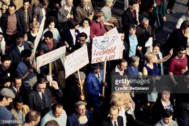 Elevated view of workers and trade union members affiliated to the CGT confederation of trade unions marching through the streets of Paris in a mass...