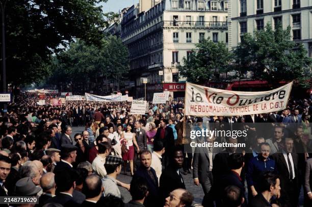 View of workers and trade union members affiliated to the CGT confederation of trade unions marching through the streets of Paris in a mass rally to...