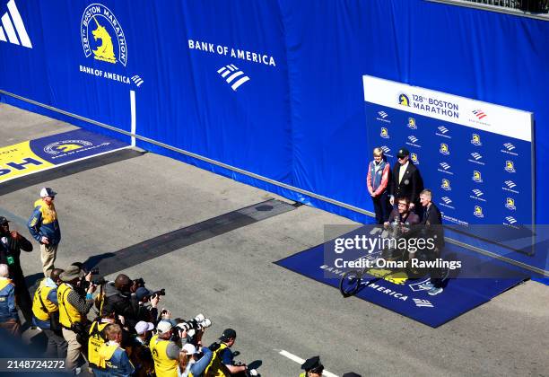 Former Boston Police Commissioner William B. Evans presents the winners trophy to Marcel Hug of Switzerland during the 128th Boston Marathon on April...