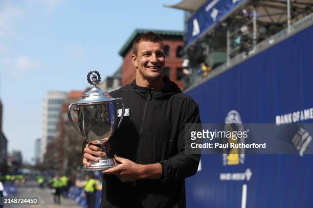 Boston Marathon grand marshal and former player for the New England Patriots Rob Gronkowski poses with the trophy during the 128th Boston Marathon on...