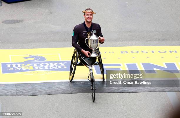 Marcel Hug of Switzerland poses with the winners trophy after taking first place in the professional Men's Wheelchair Division during the 128th...