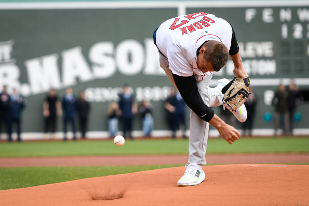 Rob Gronkowski, former NFL player for the New England Patriots spikes the ball on the mound for a ceremonial first pitch before a game between the...