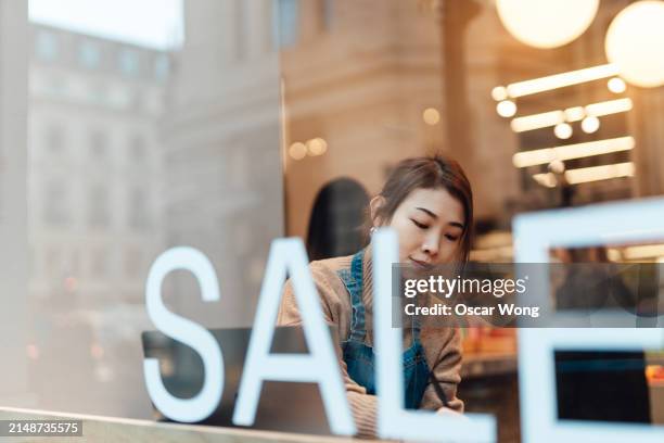female business owner doing accounting and bookkeeping with laptop, sitting in cafe - sale stock pictures, royalty-free photos & images